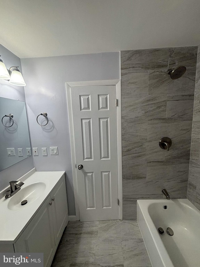 bathroom featuring tiled shower / bath combo and vanity