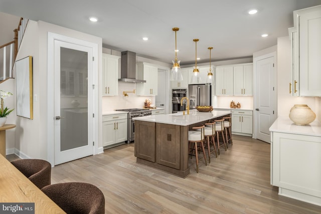 kitchen featuring a center island, premium appliances, a kitchen breakfast bar, wall chimney range hood, and pendant lighting