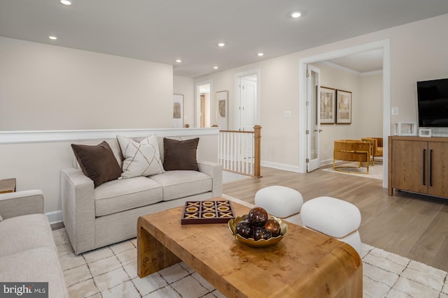 living room with light hardwood / wood-style flooring and ornamental molding