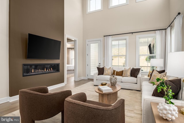 living room featuring light hardwood / wood-style flooring and a towering ceiling