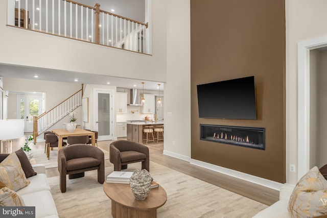 living room featuring light hardwood / wood-style flooring and a towering ceiling