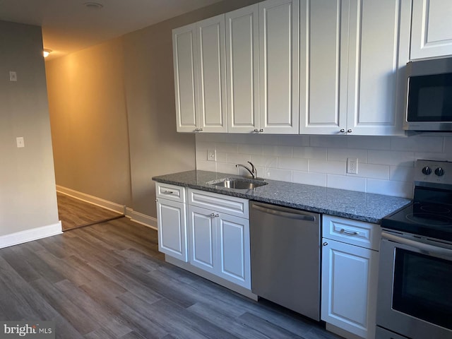 kitchen featuring stone countertops, sink, backsplash, white cabinetry, and stainless steel appliances