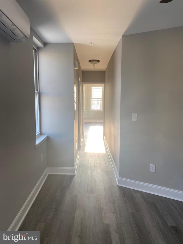 hall with dark hardwood / wood-style flooring and a wall unit AC