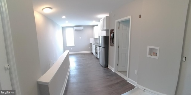 hallway with dark wood-type flooring and a wall unit AC