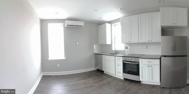 kitchen featuring backsplash, white cabinets, a wall unit AC, and stainless steel appliances