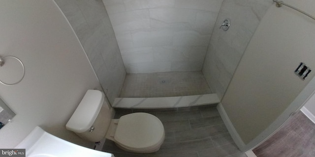 bathroom featuring toilet, a shower, and tile patterned floors