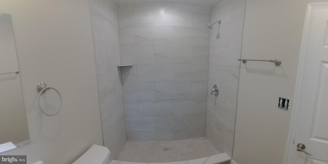 bathroom with toilet and tiled shower