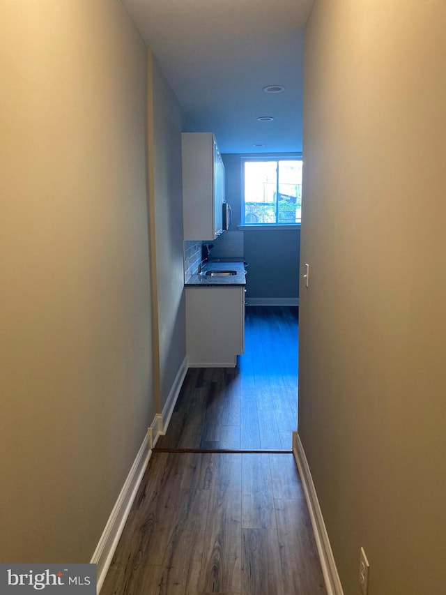 corridor featuring sink and dark hardwood / wood-style flooring