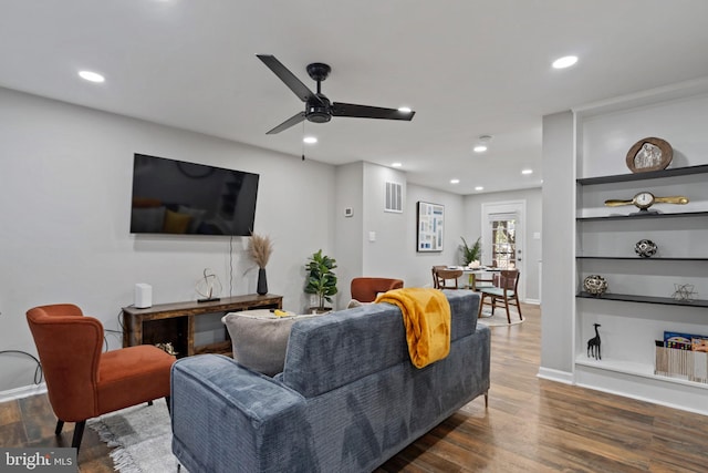 living room featuring ceiling fan, dark hardwood / wood-style flooring, and built in features