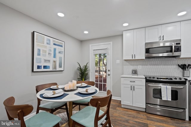 kitchen with white cabinetry, decorative backsplash, dark hardwood / wood-style floors, and appliances with stainless steel finishes