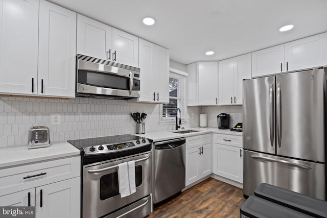 kitchen with appliances with stainless steel finishes, sink, and white cabinets