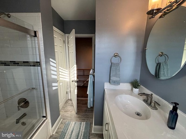 bathroom featuring vanity and bath / shower combo with glass door