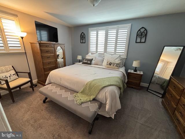 bedroom featuring dark colored carpet