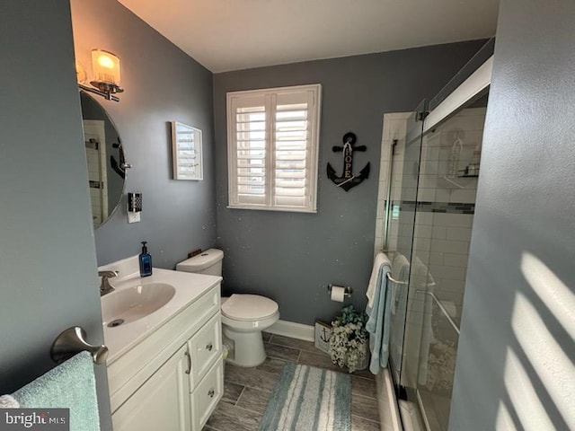 bathroom featuring vanity, toilet, and an enclosed shower