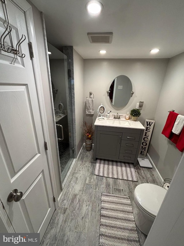 bathroom featuring vanity, toilet, and walk in shower