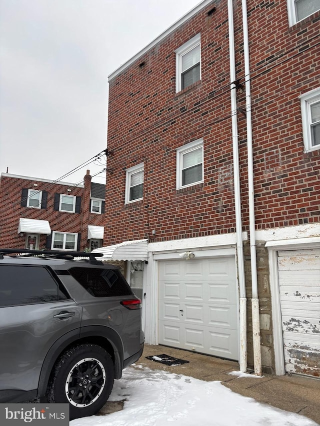 snow covered property featuring a garage