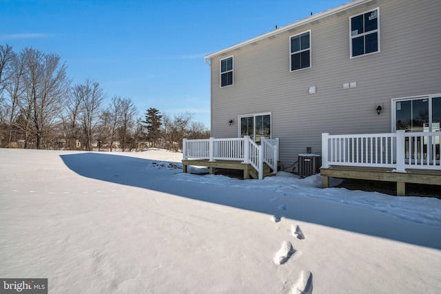 snow covered rear of property with cooling unit and a deck