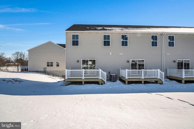 snow covered property featuring central AC unit and a wooden deck