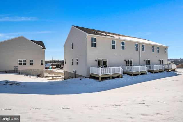 snow covered house featuring a deck