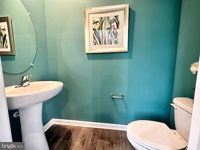 bathroom with hardwood / wood-style flooring and toilet