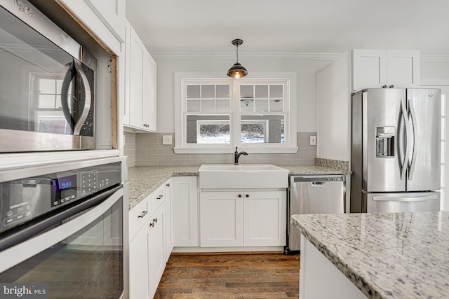 kitchen featuring pendant lighting, white cabinetry, stainless steel appliances, and sink