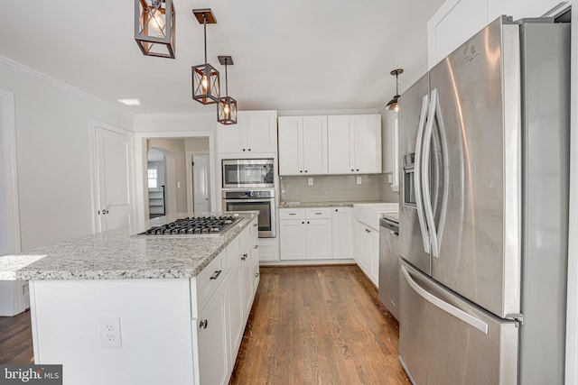 kitchen with white cabinetry, appliances with stainless steel finishes, a center island, and hanging light fixtures