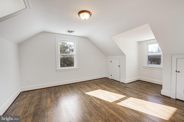 bonus room with lofted ceiling and dark hardwood / wood-style flooring