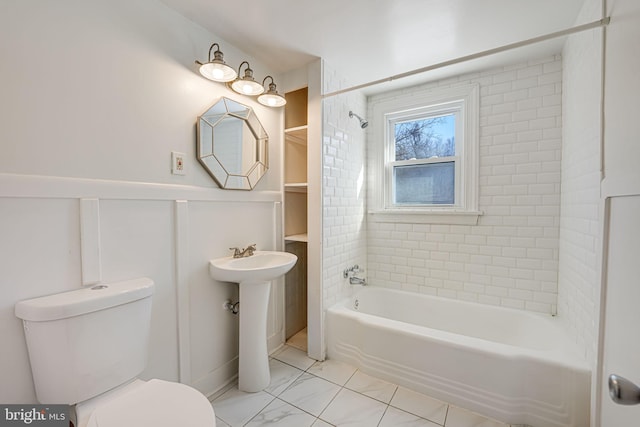 bathroom with toilet and tiled shower / bath combo