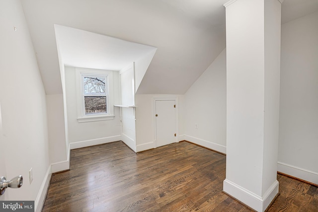 additional living space with vaulted ceiling and dark hardwood / wood-style floors