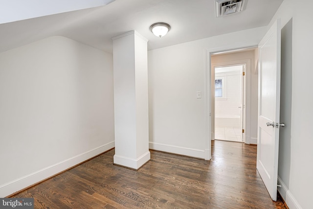 empty room with ornate columns and dark hardwood / wood-style floors