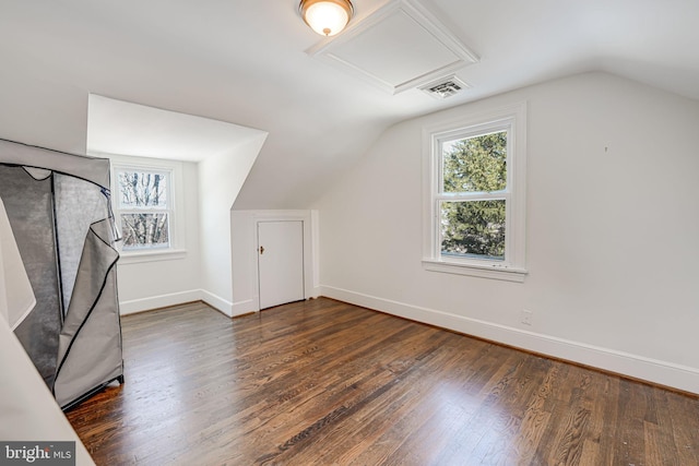 additional living space with a healthy amount of sunlight, dark hardwood / wood-style flooring, and vaulted ceiling