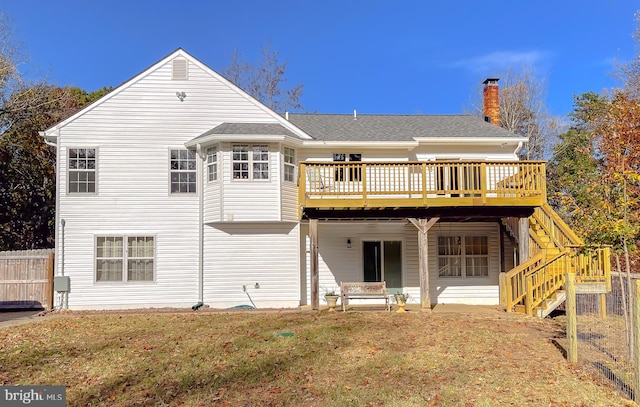 rear view of house featuring a lawn and a deck