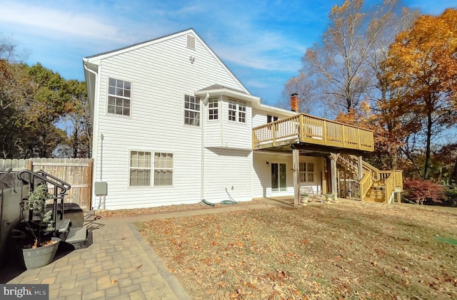 rear view of property with a deck, a patio area, and a yard