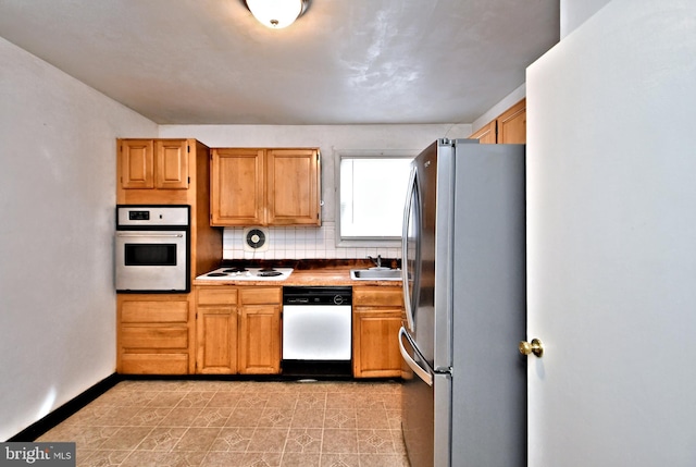 kitchen featuring stainless steel appliances, tasteful backsplash, and sink