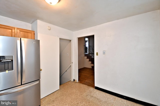 kitchen with stainless steel refrigerator with ice dispenser and light brown cabinetry