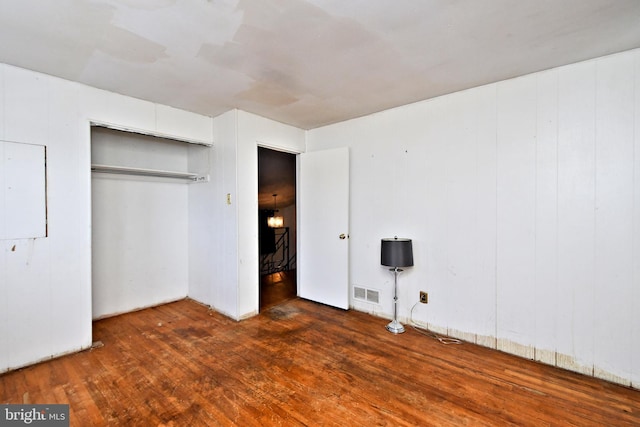 unfurnished bedroom featuring dark wood-type flooring and a closet