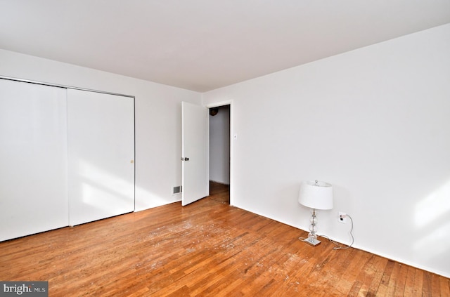 unfurnished bedroom with wood-type flooring and a closet