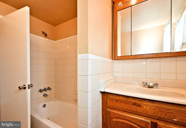 bathroom with tasteful backsplash, vanity, and tiled shower / bath combo