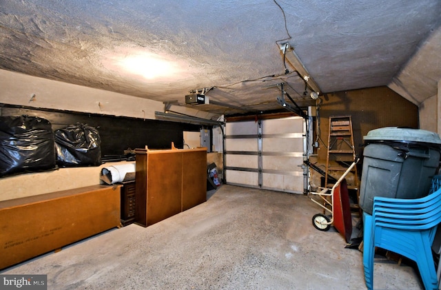 garage with a garage door opener and electric panel