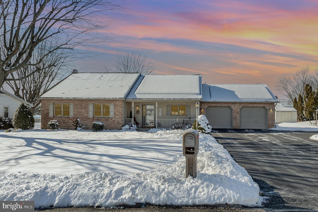 view of front of house featuring a garage, aphalt driveway, and brick siding