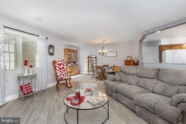 living room featuring a chandelier and light hardwood / wood-style flooring