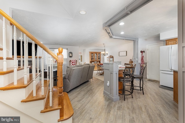 living room featuring a chandelier and light wood-type flooring