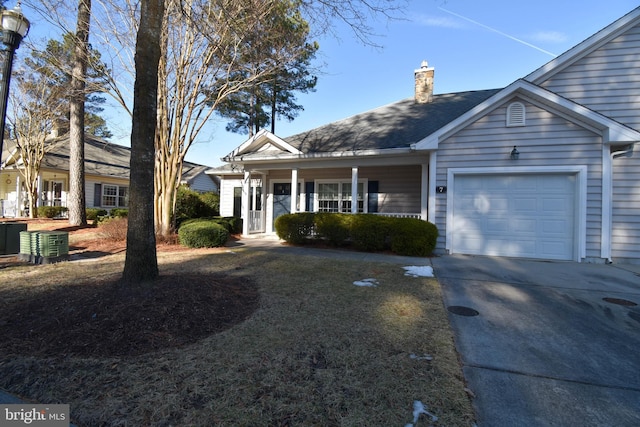 view of front of home featuring a garage, covered porch, and central air condition unit