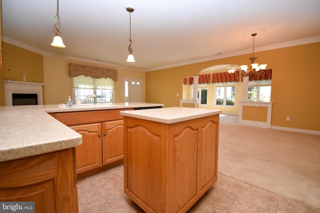 kitchen with crown molding, decorative light fixtures, light colored carpet, and a center island