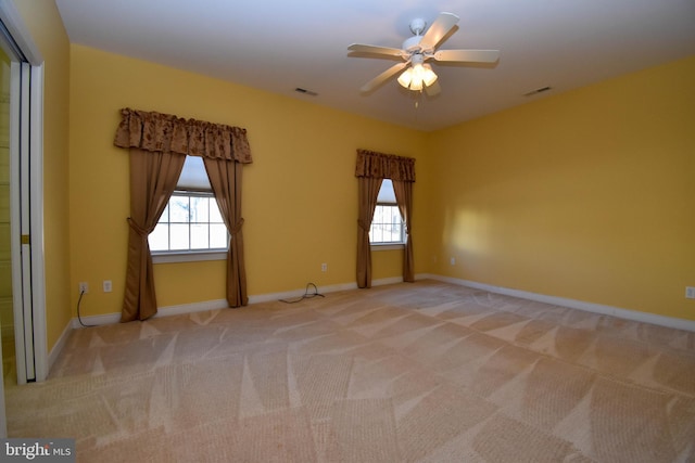 carpeted spare room featuring ceiling fan