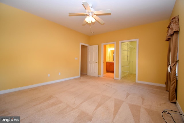 unfurnished bedroom with light carpet, connected bathroom, and ceiling fan