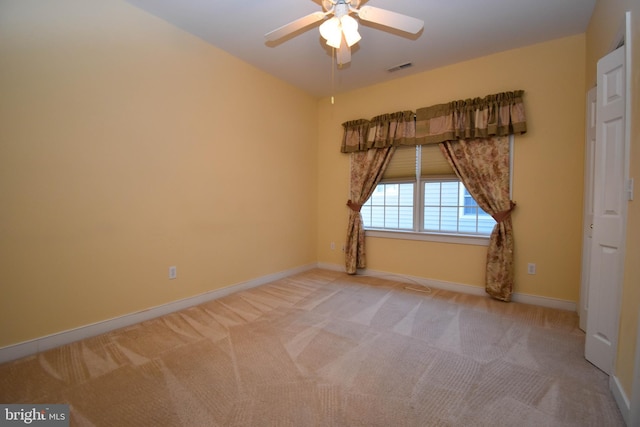 spare room featuring light colored carpet and ceiling fan