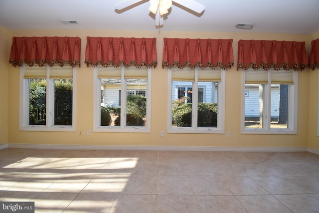 tiled empty room featuring ceiling fan