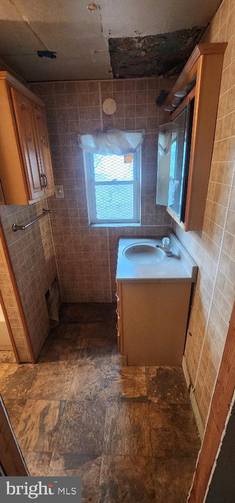 bathroom with tile walls and vanity