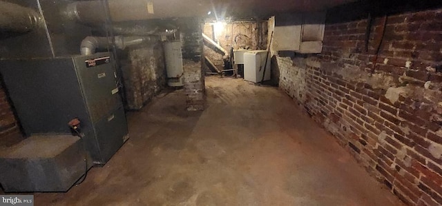 basement with water heater and washer / dryer